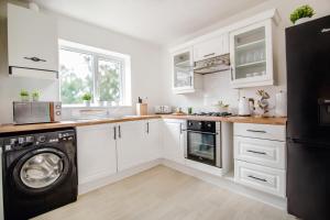 a kitchen with white cabinets and a washer and dryer at Central Cactus Escape Ideal for Long Stays 10ppl! in Nether Edge