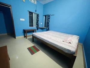 a bedroom with a bed in a blue room at Chandrakanta Guest House in Puri