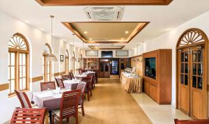 a restaurant with tables and chairs in a room at Seaflare Beach Resort & Spa in Pallipuram