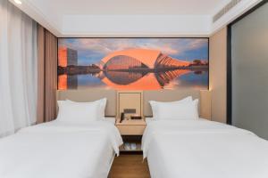 two beds in a hotel room with a large painting at Shanghai Manhua Hotel-Provides free shuttle service to Disneyland in Shanghai