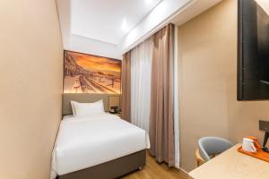 a hotel room with a bed and a painting on the wall at Shanghai Manhua Hotel-Provides free shuttle service to Disneyland in Shanghai