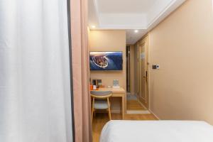 a room with a bed and a desk and a table at Shanghai Manhua Hotel-Provides free shuttle service to Disneyland in Shanghai