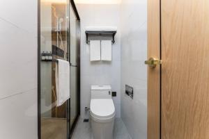 a small bathroom with a toilet and a glass door at Shanghai Manhua Hotel-Provides free shuttle service to Disneyland in Shanghai