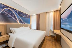 a hotel room with a bed and a flat screen tv at Shanghai Manhua Hotel-Provides free shuttle service to Disneyland in Shanghai