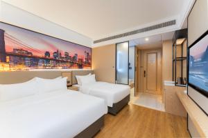 a hotel room with two beds and a flat screen tv at Shanghai Manhua Hotel-Provides free shuttle service to Disneyland in Shanghai