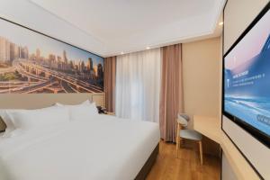 a hotel room with a bed and a flat screen tv at Shanghai Manhua Hotel-Provides free shuttle service to Disneyland in Shanghai