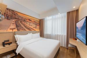 a hotel room with a bed and a flat screen tv at Shanghai Manhua Hotel-Provides free shuttle service to Disneyland in Shanghai