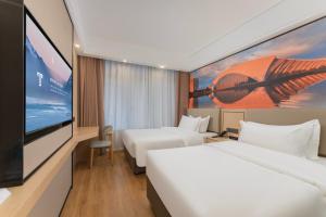 a hotel room with two beds and a flat screen tv at Shanghai Manhua Hotel-Provides free shuttle service to Disneyland in Shanghai