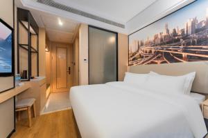 a bedroom with a large white bed and a tv at Shanghai Manhua Hotel-Provides free shuttle service to Disneyland in Shanghai