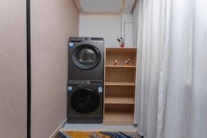 a washing machine in a room next to a curtain at Shanghai Manhua Hotel-Provides free shuttle service to Disneyland in Shanghai