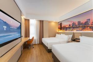 a hotel room with two beds and a flat screen tv at Shanghai Manhua Hotel-Provides free shuttle service to Disneyland in Shanghai