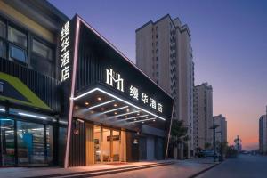 a building with a sign on the side of a street at Shanghai Manhua Hotel-Provides free shuttle service to Disneyland in Shanghai