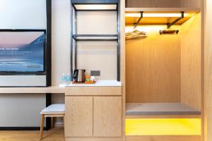 a room with a kitchen with a desk and a tv at Shanghai Manhua Hotel-Provides free shuttle service to Disneyland in Shanghai