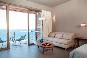 - un salon avec un canapé et une table dans l'établissement Aquila Elounda Village Resort, Suites & Spa, à Elounda