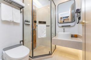 a bathroom with a shower and a toilet and a sink at Shanghai Manhua Hotel-Provides free shuttle service to Disneyland in Shanghai
