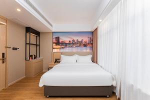 a bedroom with a white bed and a painting on the wall at Shanghai Manhua Hotel-Provides free shuttle service to Disneyland in Shanghai