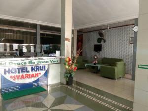 a lobby with a hotel kiwi sandwich sign in a building at Hotel krui syariah in Krui