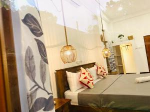 a bedroom with two beds and a hanging lamp at Diamond Key Ahangama in Piyadigama