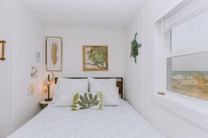 a white bedroom with a bed and a window at NH337A Coastal Dunes 1 in Nags Head