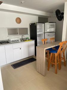 een keuken met een tafel, stoelen en een koelkast bij Apartamento Familiar in Carmen de Apicalá