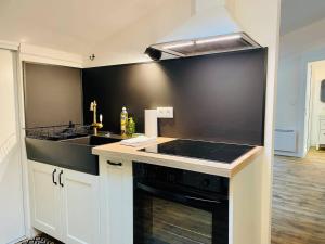 a kitchen with a stove and a sink at Le Boudoir de Thais in La Rochelle +41 photos