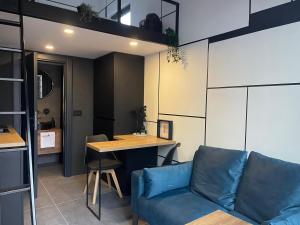 a living room with a blue couch and a table at Garage Apartments in Bajina Bašta