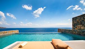 - une piscine avec vue sur l'océan dans l'établissement Aquila Elounda Village Resort, Suites & Spa, à Elounda