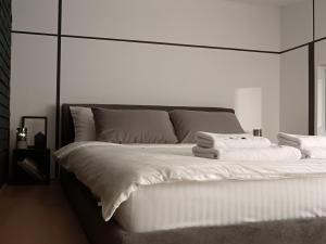 a bedroom with a large white bed with towels on it at Garage Apartments in Bajina Bašta