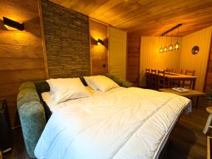 a large bed in a room with a brick wall at Les Orres 1800 - Spacieux T3 6 pers SUD Vue Piste in Le Mélézet +13 photos