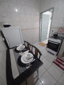 a kitchen with a table with plates on it at Arraial do Cabo - Flat Paraíso II in Arraial do Cabo