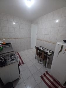 a kitchen with a stove and a table in it at Arraial do Cabo - Flat Paraíso II in Arraial do Cabo
