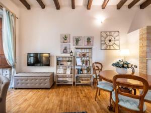 a living room with a table and a tv at Estay - Charm in Villanova in Cagliari +19 photos