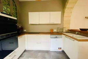 una cocina con armarios blancos y un aparato negro en La Casa de Pape, Hypercentre, LR138, en La Rochelle 66 fotos más