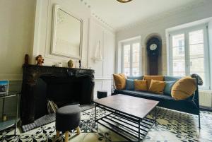 Una sala de estar con un sofá azul y una chimenea. en La Casa de Pape, Hypercentre, LR138, en La Rochelle