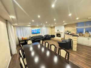 a living room with a table and chairs and a kitchen at Vila Florilor Predeal in Predeal