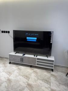a flat screen tv sitting on top of a tv stand at جود ان للشقق الفندقية in Aţ Ţunḑubāwī
