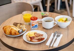 a table with two plates of breakfast food on it at B&B HOTEL Bordeaux Bassins à flot in Bordeaux