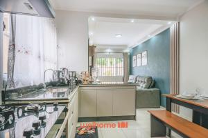 a kitchen with a sink and a couch at Casa em Itanhaém com piscina a 5 minutos da praia in Itanhaém