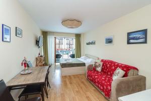 a living room with a red couch and a table at Charming Studio Escape in Prime Ski Location in Gudauri +31 photos
