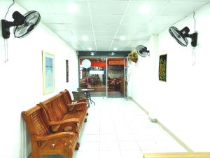 南芭堤雅Marine Guest House Encore的一间设有棕色椅子和桌子的等候室