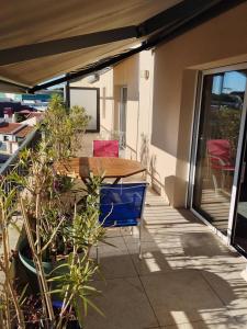 patio z drewnianym stołem i roślinami w obiekcie Appartement a proximité du centre et de la Plage a Meze w mieście Mèze