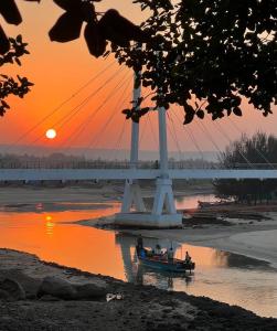 a boat in the water in front of a bridge at Turtle Beach House in Vengurla