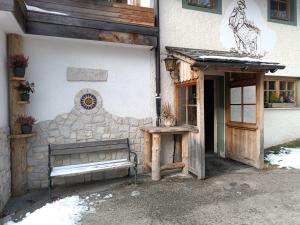 a building with a bench in front of a building at kuglerhof in Dobbiaco