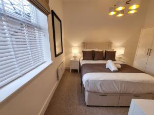 a small bedroom with two beds and a window at Luxury Altrincham Flat by City SuperHost in Altrincham