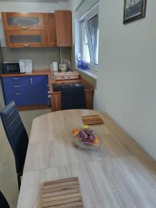 a bowl of fruit on a wooden table in a kitchen at Apartments Miličević in Gradac +19 photos