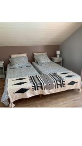 a bedroom with two beds and a white ceiling at maison bleue in Biscarrosse