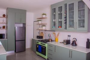 een keuken met een groen fornuis en een koelkast bij Casa Linda in Harare