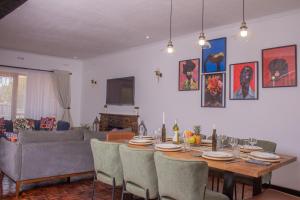 een woonkamer met een eettafel en stoelen bij Casa Linda in Harare