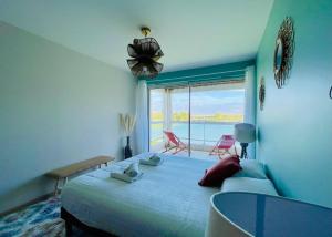a bedroom with a bed with a view of the ocean at Le Cottage du Lac, centre ville, LR124 in La Rochelle