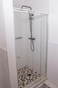 een douche met een glazen douchewand en een handdouche bij Casa Linda in Harare